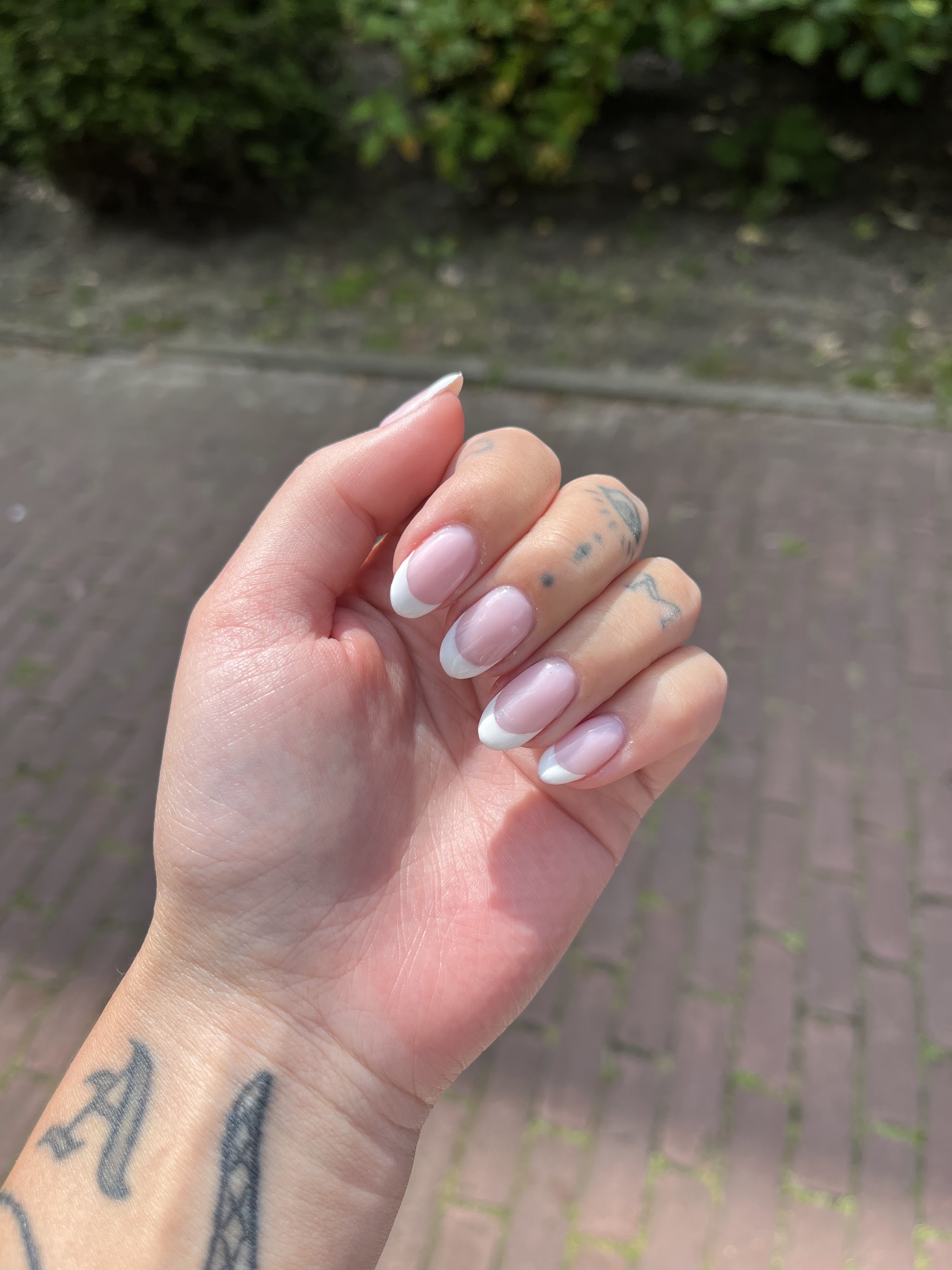 Amandelvormige nagels met witte French tips, buiten gefotografeerd